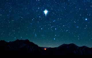 A star shining over a small campfire.